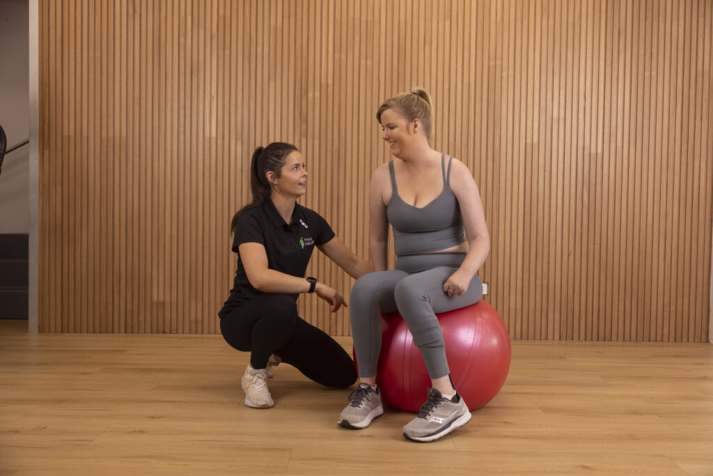 physio with client on exercise ball