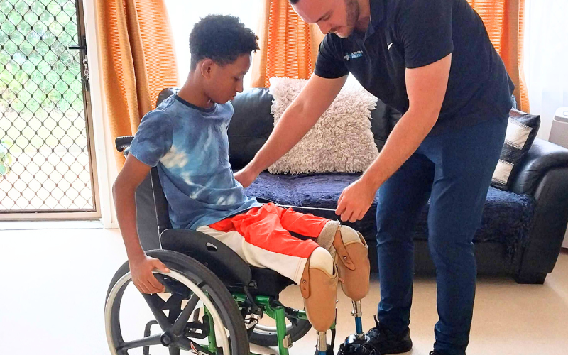 OT assisting with a child's wheelchair set up